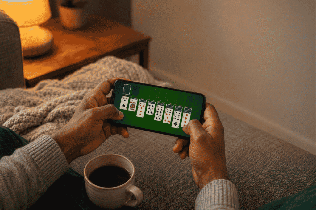 Best solitaire games for Android shown on a phone during a cozy evening at home
