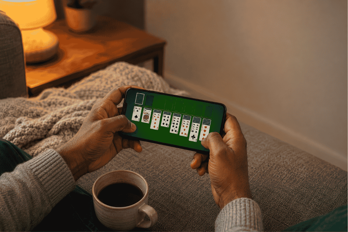 Best solitaire games for Android shown on a phone during a cozy evening at home